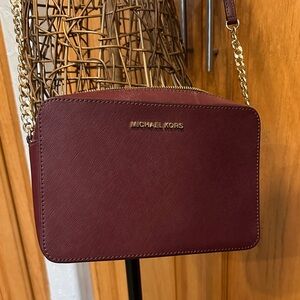 Michael Kors Oxblood Jet Set Bag with Gold Hardware.